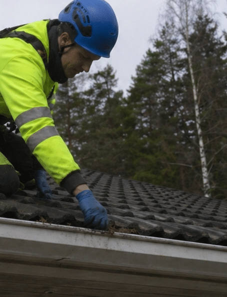 Rännin puhdistamista katon reunalla